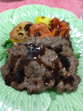 Herbs and balsamic cream bbq ribeyes steak on a bed of rockets served with roasted vegetables.jpg