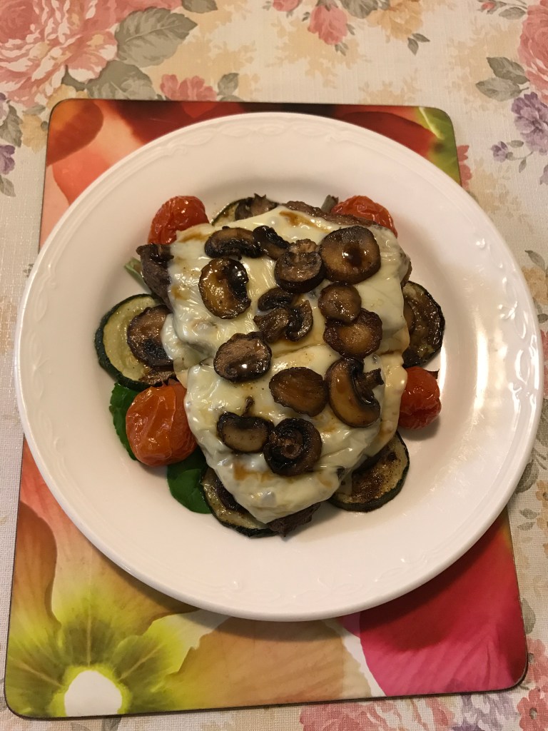 Rump Swiss cheese with baked mushrooms, zucchini cherries tomatoes on a bed of salad